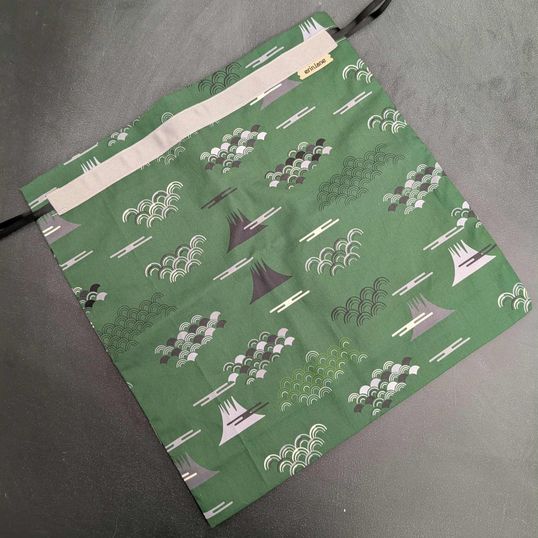 Green fabric bag with a pattern on a gray surface